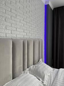 1 cama con almohadas blancas y pared de ladrillo en Апартаменты люкс класса, en Pavlodar