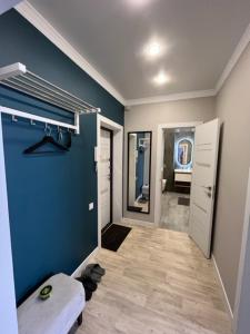 baño con pared azul y espejo en Апартаменты люкс класса, en Pavlodar