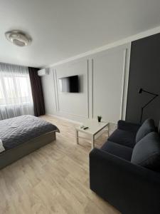 sala de estar con cama y sofá en Апартаменты люкс класса, en Pavlodar