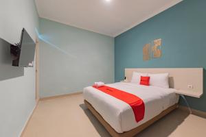 a bedroom with a bed and a television in it at RedDoorz Plus near Surapati Core in Bandung