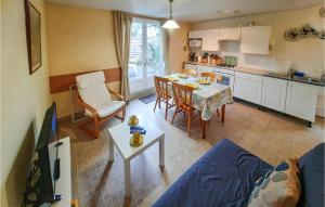 een keuken en een woonkamer met een blauwe bank en een tafel bij Amazing Home In Bannalec With Kitchenette in Bannalec