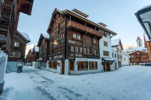 a building on a street with snow on the ground at Sonne Andermatt Swiss Quality Hotel in Andermatt