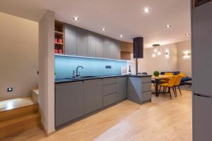 a kitchen with a sink and a table with yellow chairs at Exclusive New York Residence in the Heart of Budapest in Budapest