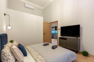 1 dormitorio con 1 cama y TV de pantalla plana en Exclusive New York Residence in the Heart of Budapest, en Budapest