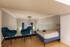a bedroom with a bed and two chairs at Exclusive New York Residence in the Heart of Budapest in Budapest