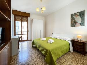 um quarto com uma cama verde e uma televisão em Casa Gramsci - Affitti Brevi Italia em Módena