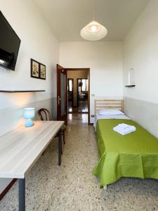 um quarto com duas camas e uma mesa e uma televisão em Casa Gramsci - Affitti Brevi Italia em Módena