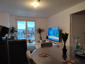 a living room with a table and a television at Parc EXPO prte d'orléans ORLY CDG Terrasse parking in Bagneux