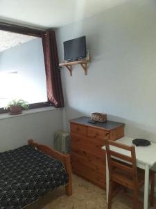 a bedroom with a bed and a table and a tv at Cap Dauphiné in Grenoble