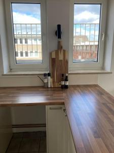 a kitchen with two windows and a wooden counter top at Rooftop mit Fördeblick, zentral & nah am HBF in Kiel