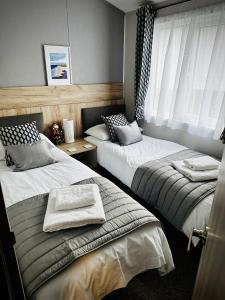 1 dormitorio con 2 camas y toallas. en C-Scape Lodge en Newquay