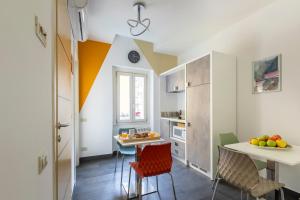 eine Küche mit orangefarbenen und weißen Wänden und einem Tisch mit Stühlen in der Unterkunft La Riviere Guesthouse Trastevere in Rom