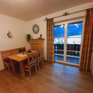 ein Esszimmer mit einem Tisch und einem großen Fenster in der Unterkunft Ferienwohnungen Haus Martin in Inzell