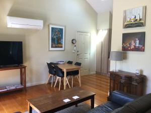 a living room with a couch and a table with chairs at Port Boutique Accommodation in Port Fairy