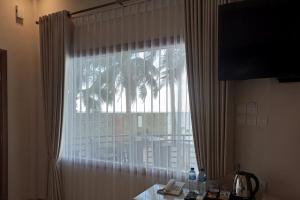 um quarto com uma janela com uma mesa e um telefone em Watuduya Resort by The Lavana em Pasarbaru