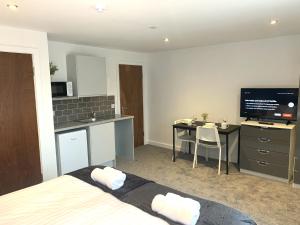 a room with a bed and a kitchen and a table at NelsonStays Self-Contained Studios Stoke on Trent in Stoke on Trent