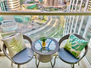 d'un balcon avec des chaises et une table offrant une vue sur la ville. dans l'établissement White Sage - Lakefront Apartment Amidst Parks With Lake Access, à Dubaï