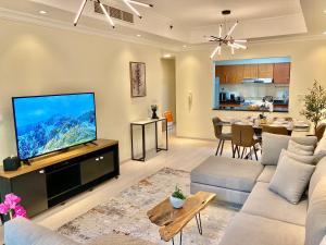 a living room with a large flat screen tv at White Sage - Lakefront Apartment Amidst Parks With Lake Access in Dubai