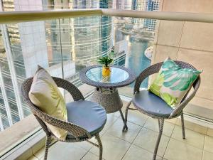 a table and chairs on a balcony with a view at White Sage - Lakefront Apartment Amidst Parks With Lake Access in Dubai