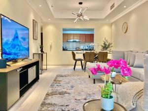 a living room with a couch and a tv at White Sage - Lakefront Apartment Amidst Parks With Lake Access in Dubai