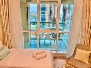 a bedroom with a bed with a towel on it at White Sage - Lakefront Apartment Amidst Parks With Lake Access in Dubai