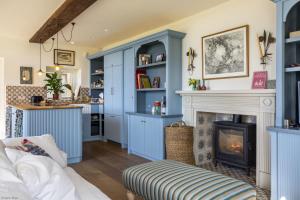 a living room with blue cabinets and a fireplace at Leconfield Lodge in Petworth