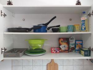 a shelf with pots and pans and other kitchen items at Cap Dauphiné in Grenoble