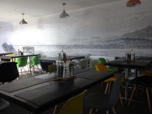 a restaurant with tables and chairs and a mural on the wall at Shepherds Hut, Jamies Retreat, Bowness-on-Solway in Bowness-on-Solway