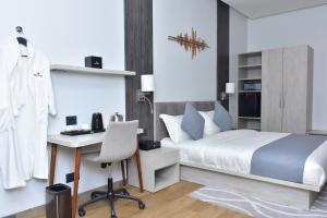 KinshasaHotel Stella的一间卧室，配有一张床和一张带电脑的书桌