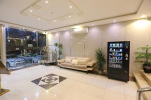 a lobby with a couch and a drink machine at إطلالة الواحة للشقق المخدومة in Al Majmaah
