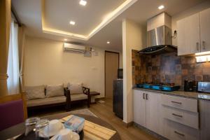 cocina y sala de estar con sofá y mesa en Sarovar Residency Serviced Apartment Hotel, en Jawlakhel