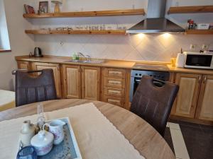 德魯哈法的住宿－Apartmány Skalka，厨房配有桌子、两把椅子和微波炉