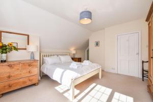 a bedroom with a bed and a dresser and a mirror at Sea Way in Middleton-on-Sea