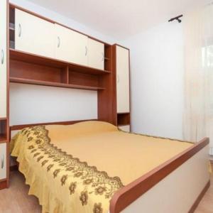 a bedroom with a bed with a yellow bedspread at Apartments Marko in Okrug Donji