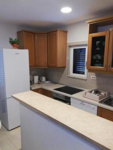 a kitchen with wooden cabinets and a white refrigerator at Apartments Marko in Okrug Donji