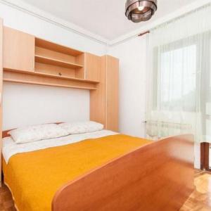a bedroom with a bed with a yellow blanket at Apartments Marko in Okrug Donji