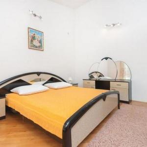 a bedroom with a bed and two mirrors on the wall at Apartments Marko in Okrug Donji