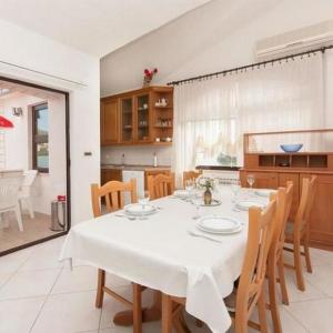 a dining room with a table and a kitchen at Apartments Marko in Okrug Donji