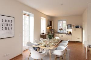 a kitchen and dining room with a table and white chairs at ErholungNOW in Bispingen