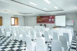 a conference room with white chairs and a screen at Front One Resort Indraloka Temanggung in Temanggung