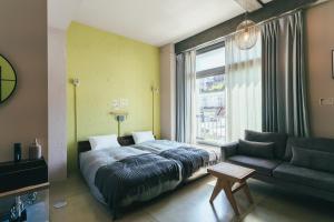 1 dormitorio con cama, sofá y ventana en Kiten - slow & work stay -, en Atami