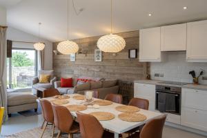 a kitchen and living room with a table and chairs at Sea Breezes in Pagham