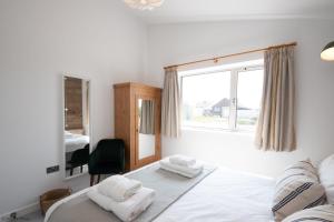 a bedroom with a bed with towels on it at Sea Breezes in Pagham