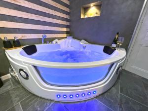 wanna z niebieską wodą w pokoju w obiekcie Gîte cosy avec Jacuzzi classé 3 étoiles w mieście Poncin +8 zdjęć