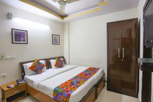 una camera con un grande letto e una porta in legno di FabExpress The Paradise a Nuova Delhi