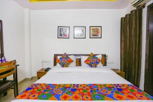 una camera da letto con un grande letto e un piumone colorato di FabExpress The Paradise a Nuova Delhi