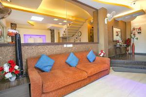 un divano arancione con cuscini blu nella hall di FabExpress The Paradise a Nuova Delhi