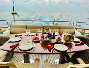 a table on the deck of a boat with food and wine at GALAKTIKA SKAY YACHT in Hulhumale