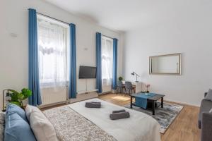 un soggiorno con divano blu e tavolo di Exclusive Central Home with Sauna next to the New York Café a Budapest