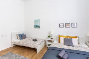 1 Schlafzimmer mit 2 Betten und einem Sofa in der Unterkunft Exclusive Central Home with Sauna next to the New York Café in Budapest